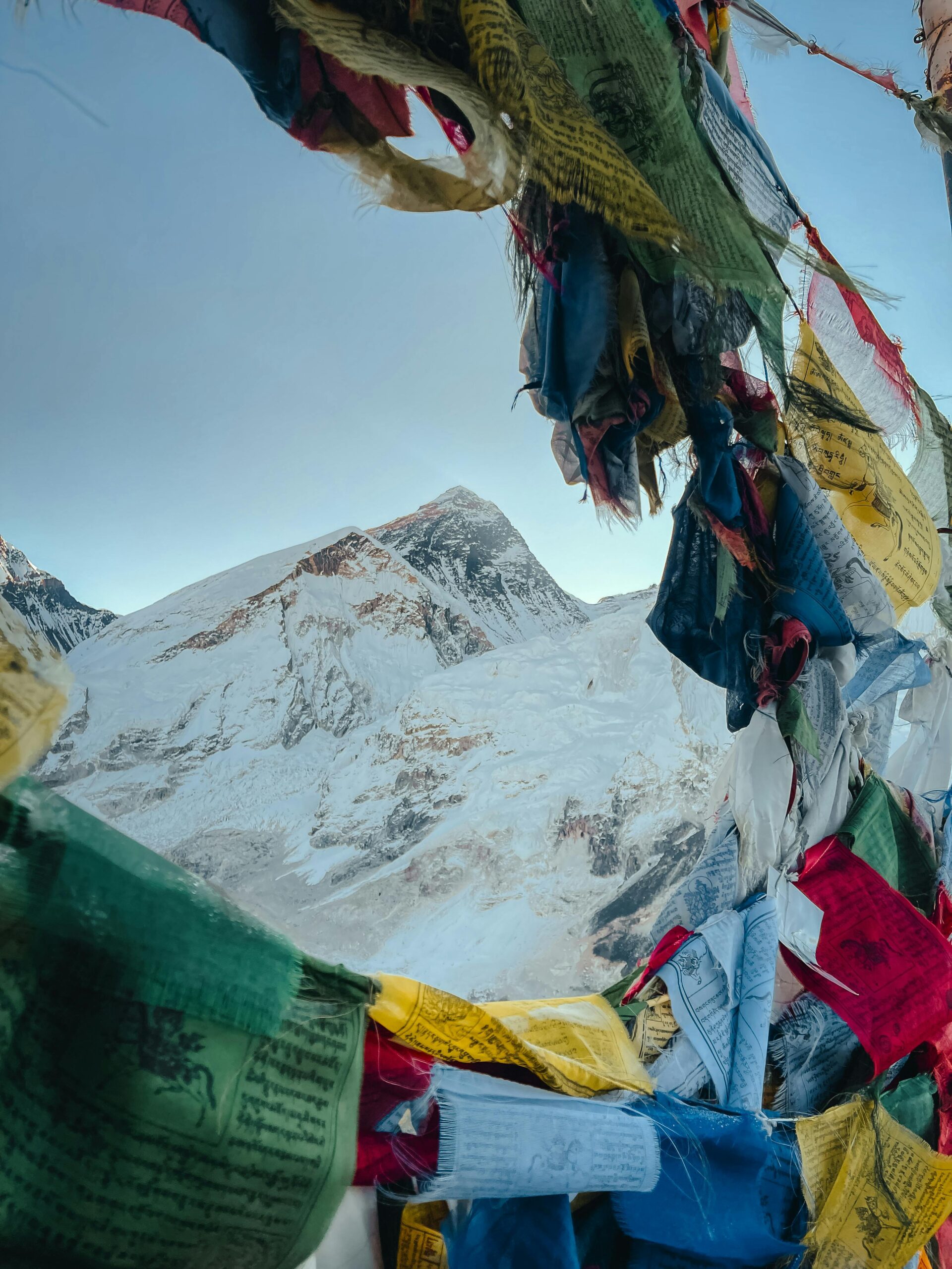 Home View of Mount Everest framed by colorful Tibetan prayer flags, capturing the peak's grandeur.